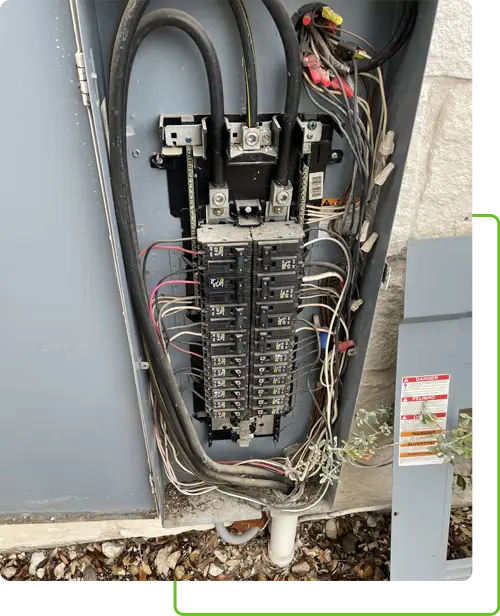 Electrical panel with exposed wiring and circuit breakers, showcasing expert electrical services in TX for system components.