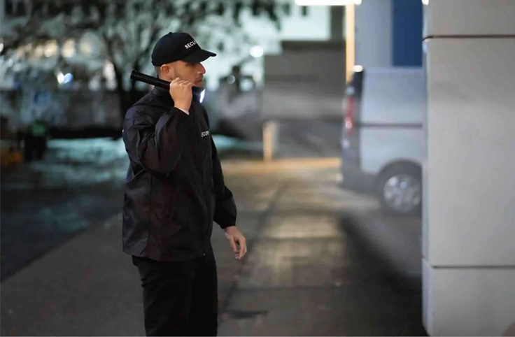 A man holding a torch in a warehouse, ensuring visibility and safety while working in low-light or emergency situations